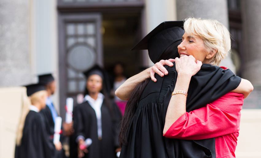 Woman hugging college grad