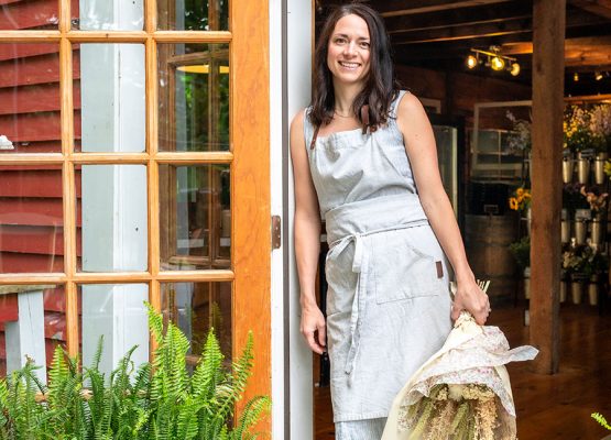 Woman holding a bouquet of flowers in the doorway