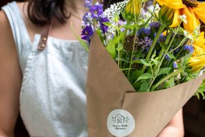 Woman holding a bouquet of flowers at Barn INN Bloom gift & flower shop
